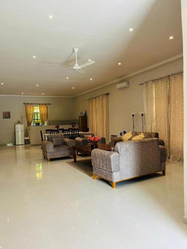 a living room with two couches and a living room with a ceiling at Blossom House Zanzibar in Kitongani