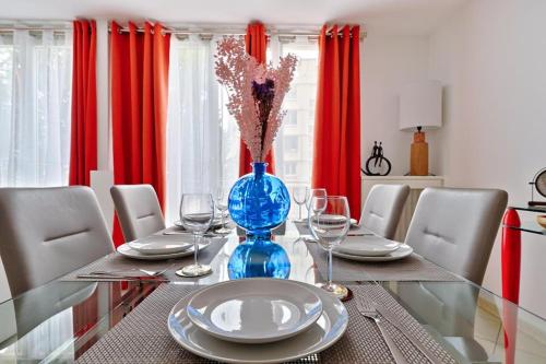 une salle à manger avec une table en verre et des rideaux rouges dans l'établissement Welcome to Celia House, à Vitry-sur-Seine