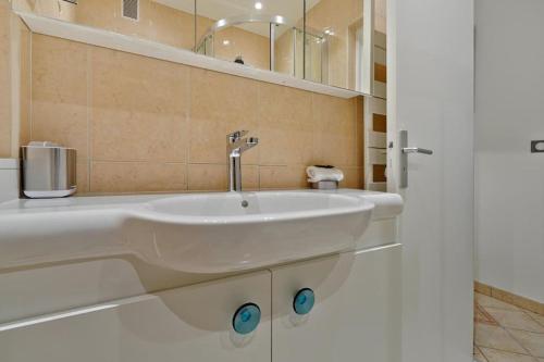 une salle de bain avec un lavabo blanc et un miroir dans l'établissement Welcome to Celia House, à Vitry-sur-Seine