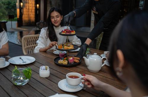 a group of people sitting at a table eating food at Plataran Puncak Residences in Puncak