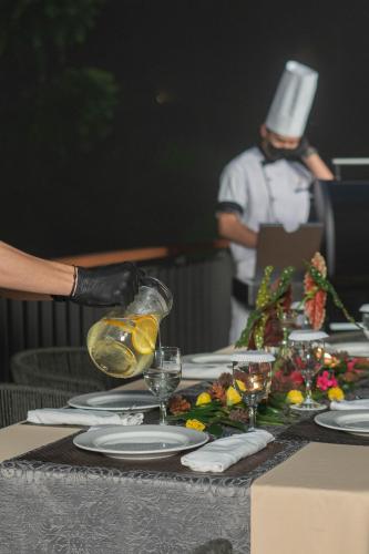 a person in a top hat pouring wine into a table at Plataran Puncak Residences in Puncak