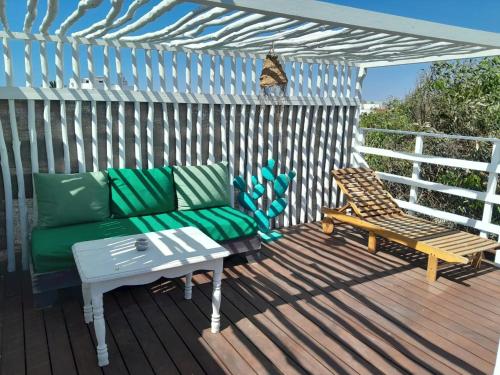 a patio with a couch and a bench on a deck at Vent Des Dunes in Essaouira
