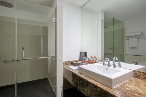 a bathroom with a sink and a mirror at Hotel Santika Cikarang in Cikarang