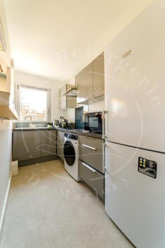 La cuisine est équipée d'un réfrigérateur blanc et d'un lave-vaisselle. dans l'établissement Haute Ville - T2 cosy avec clim & balcon, à Toulon