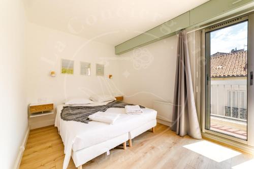 une chambre avec un lit et une grande fenêtre dans l'établissement Haute Ville - T2 cosy avec clim & balcon, à Toulon