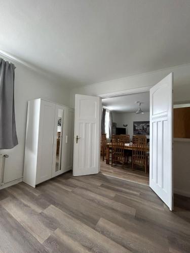 an empty living room with two doors and a dining room at Ferienwohnung Grevesmühlen in Grevesmühlen