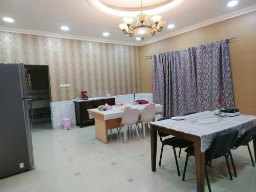 a dining room with a table and chairs and a chandelier at Fujairah Korean Guest House KUA in Fujairah