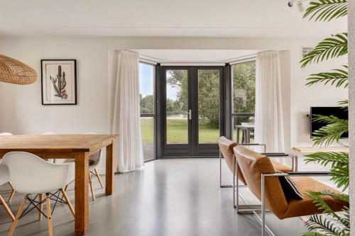 a dining room with a wooden table and chairs at Vakantiehuis aan het water -incl laadpaal- in Ewijk