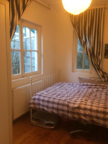 a bedroom with a bed and two windows at Kınalıada manzaralı ev in Adalar