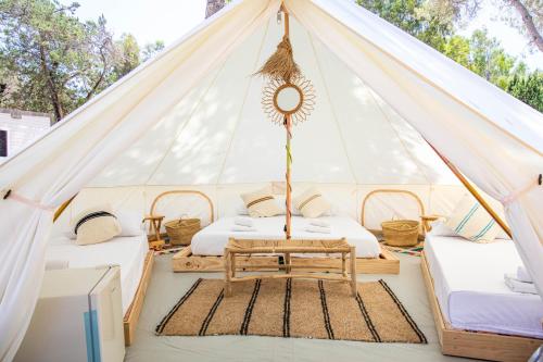 a tent with two beds and a table in it at HolaCamp Sant Salvador in Comarruga
