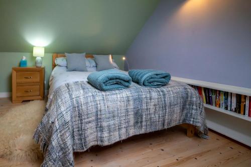 una camera da letto con un letto con asciugamani blu sopra di The Old Coastguard Station, Lochinver a Lochinver