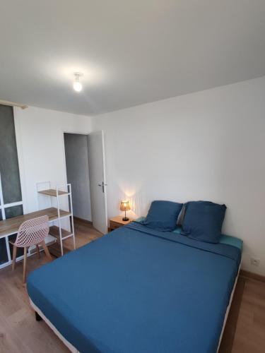 - une chambre avec un lit bleu et une table dans l'établissement Charmant T4, Proche des Remparts, à Avignon