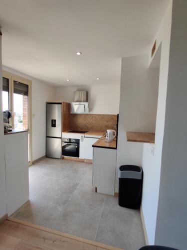 une cuisine avec des placards blancs et un comptoir dans l'établissement Charmant T4, Proche des Remparts, à Avignon