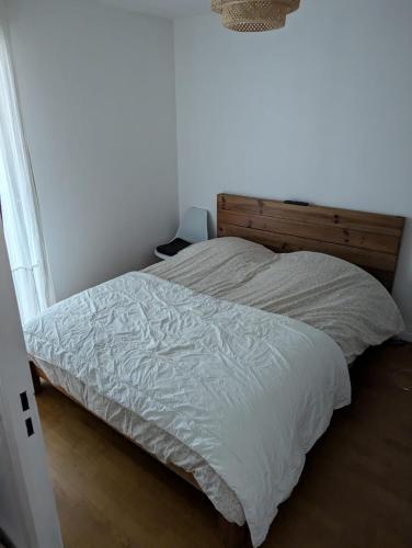 - un lit sans tête de lit en bois dans l'établissement Prox Stade France appart 2P Chaleureux, à Saint-Denis