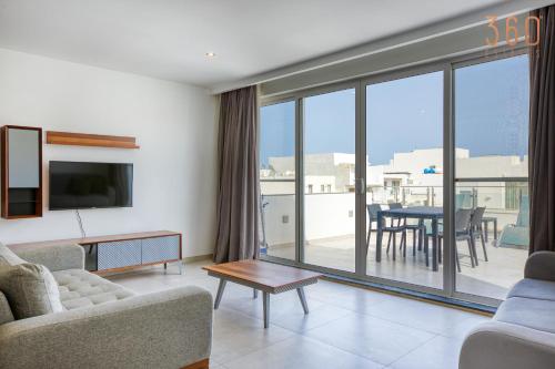 a living room with a couch and a table at The Swieqi Poolside Suites in Is-Swieqi