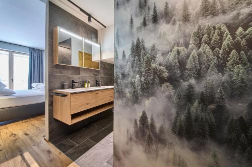 a bathroom with a mural of trees on the wall at sGmiatli – Dein Hideaway Apartment in Kappl