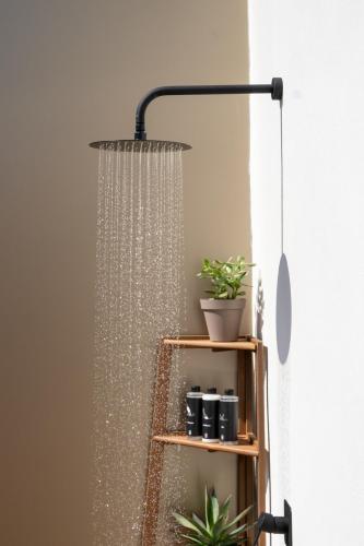 a hanging shower head in a room with a shelf with potted plants at Ocean Drive Sevilla in Seville