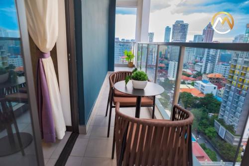 a balcony with a table and chairs and a city at Hotel Serviced Apartments Top One Infinity Pool with View of 360 Degree in Phnom Penh