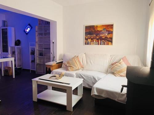 a living room with a white couch and a table at Apartamento de la Cruz in Merida