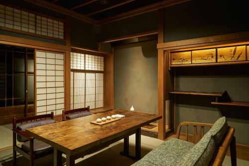 a dining room with a wooden table and chairs at Bed and Craft in Nanto