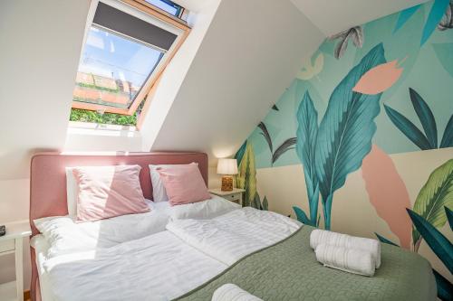 a bedroom with a bed with a plant mural on the wall at Monbuhim Twin in Veszprém