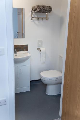 ein weißes Badezimmer mit Toilette und Waschbecken in der Unterkunft Hotel Rafay in Blackburn