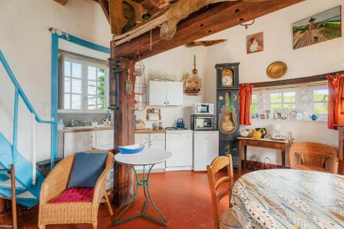 une cuisine avec une table et une salle à manger dans l'établissement Ancien moulin à vent du 19e siècle, à Cherrueix