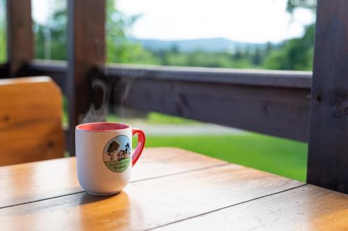 a coffee cup sitting on top of a wooden table at Agroturystyka W oddali z balią in Międzylesie