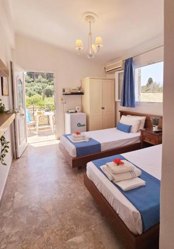 a hotel room with two beds and a balcony at Villa Kormos Apart Hotel in Kavos