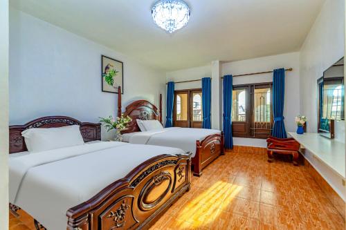 a bedroom with two beds and a chandelier at 万象莉莉酒店 Lilyhotel in Vientiane