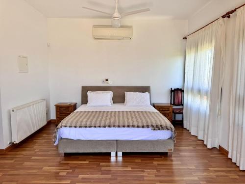 a bedroom with a bed and a ceiling fan at Mountain view 6 bed mansion with Private Padel Court, Pool & Gym in Larnaka