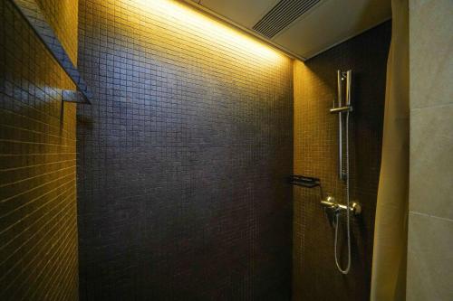a bathroom with a shower with a wall at The Salvation Army - Booth Lodge in Hong Kong