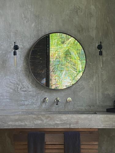 a bathroom sink with a mirror on the wall at KAJU GREEN eco lodges in Unawatuna