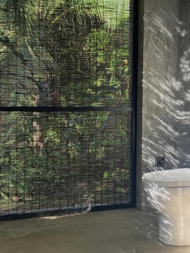 a toilet sitting next to a window with a gate at KAJU GREEN eco lodges in Unawatuna