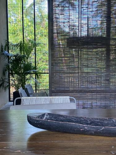 a room with a bench and a table and windows at KAJU GREEN eco lodges in Unawatuna