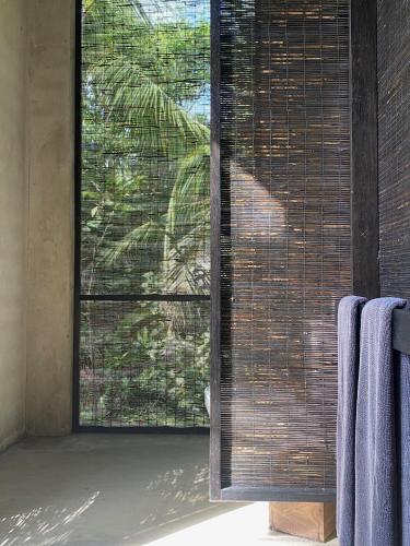 a bathroom with a window with blinds on it at KAJU GREEN eco lodges in Unawatuna