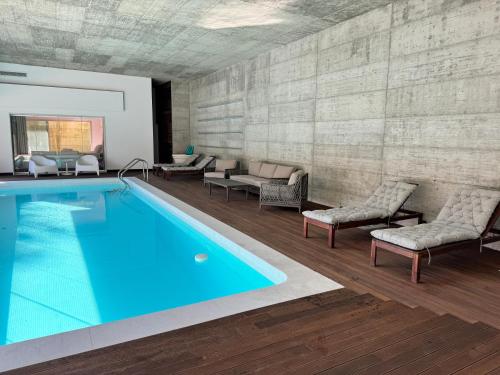 a swimming pool with chairs and a couch at Poolside Suite - Heated Shared Pool-Quinta da BellaVista in Santarém