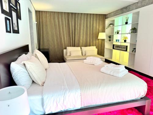 a bedroom with a large bed with two towels on it at Poolside Suite - Quinta da BellaVista in Santarém