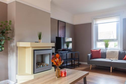 a living room with a fireplace and a couch at Beth House in Bathgate