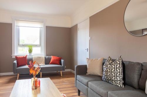 a living room with a couch and a table at Beth House in Bathgate