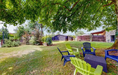 a group of lawn chairs sitting under a tree at Nice Home In Mareuil En Perigord in Cercles