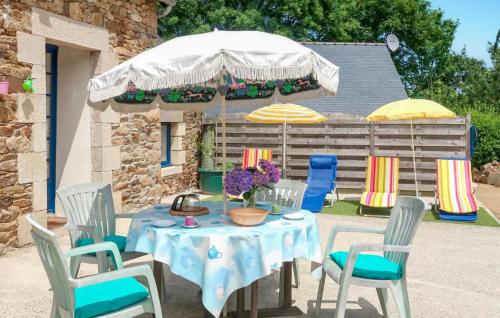 a table with chairs and an umbrella in a yard at Beautiful Home In Plouha With Wifi in Plouha
