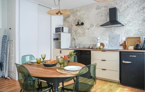 a kitchen with a wooden table and green chairs at Stunning Apartment In Saint-Renan in Saint-Renan