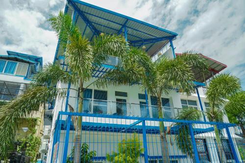 a building with palm trees in front of it at The Neeraj Ganga Cottages in Rishīkesh