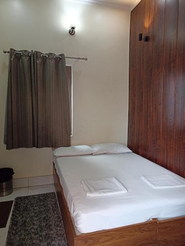 Un dormitorio con una cama con un armario de madera. en Hotel Alka, en Varanasi