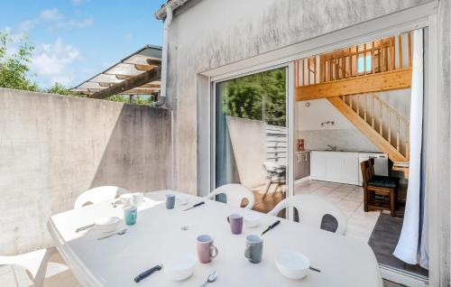une salle à manger avec une table blanche et des chaises blanches dans l'établissement Gorgeous Home In Mornac-Sur-Seudre, à Mornac-sur-Seudre