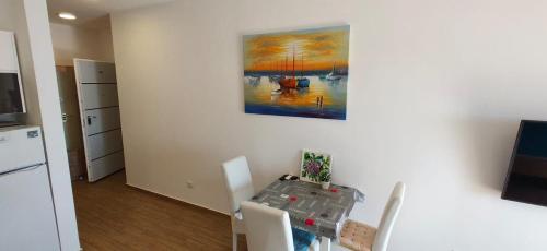 a kitchen with a table and a painting on the wall at Your Home Montenegro in Dobra Voda