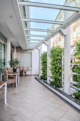 an office lobby with a glass ceiling and plants at Hotel Orizzonte in Lido di Jesolo