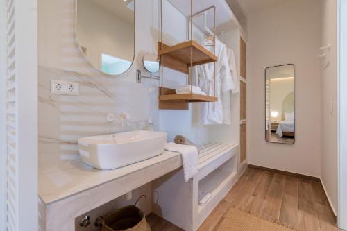 a white bathroom with a sink and a mirror at Pnoe Luxury Villa in Ierissos