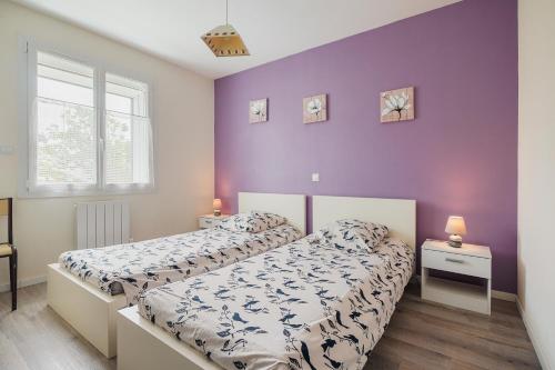 two beds in a bedroom with purple walls at Kermat in Matignon